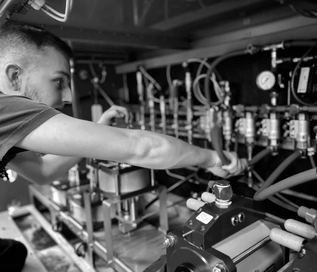 Arbeiter bedient Maschine mit Hydrauliksystem in einer Werkstatt